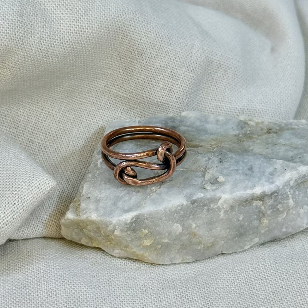 Copper wire ring on a stone surface with a linen background