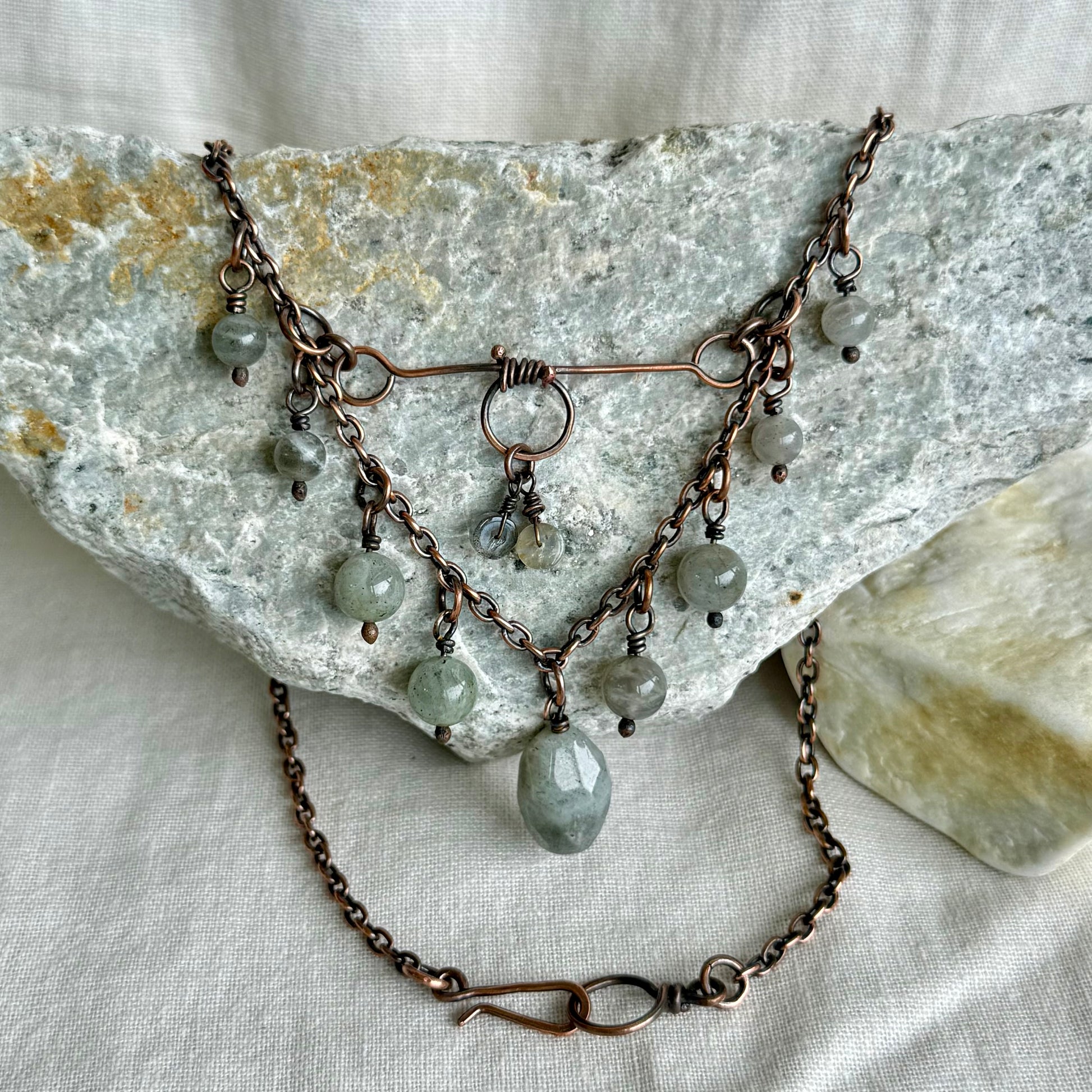Copper Necklace with grey beads on a stone surface