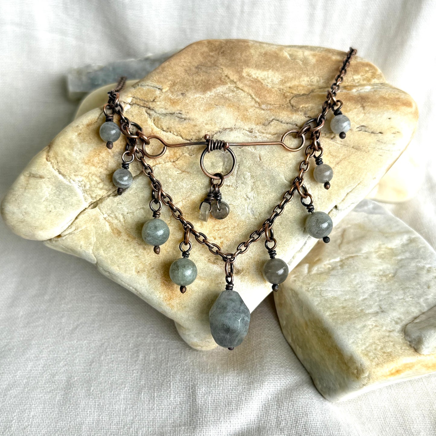 Copper Necklace with gray beads on a stone surface