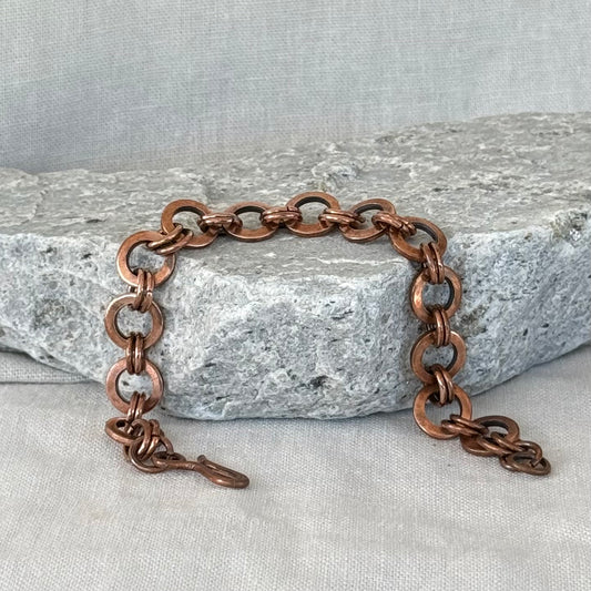 Copper chain bracelet on a stone surface