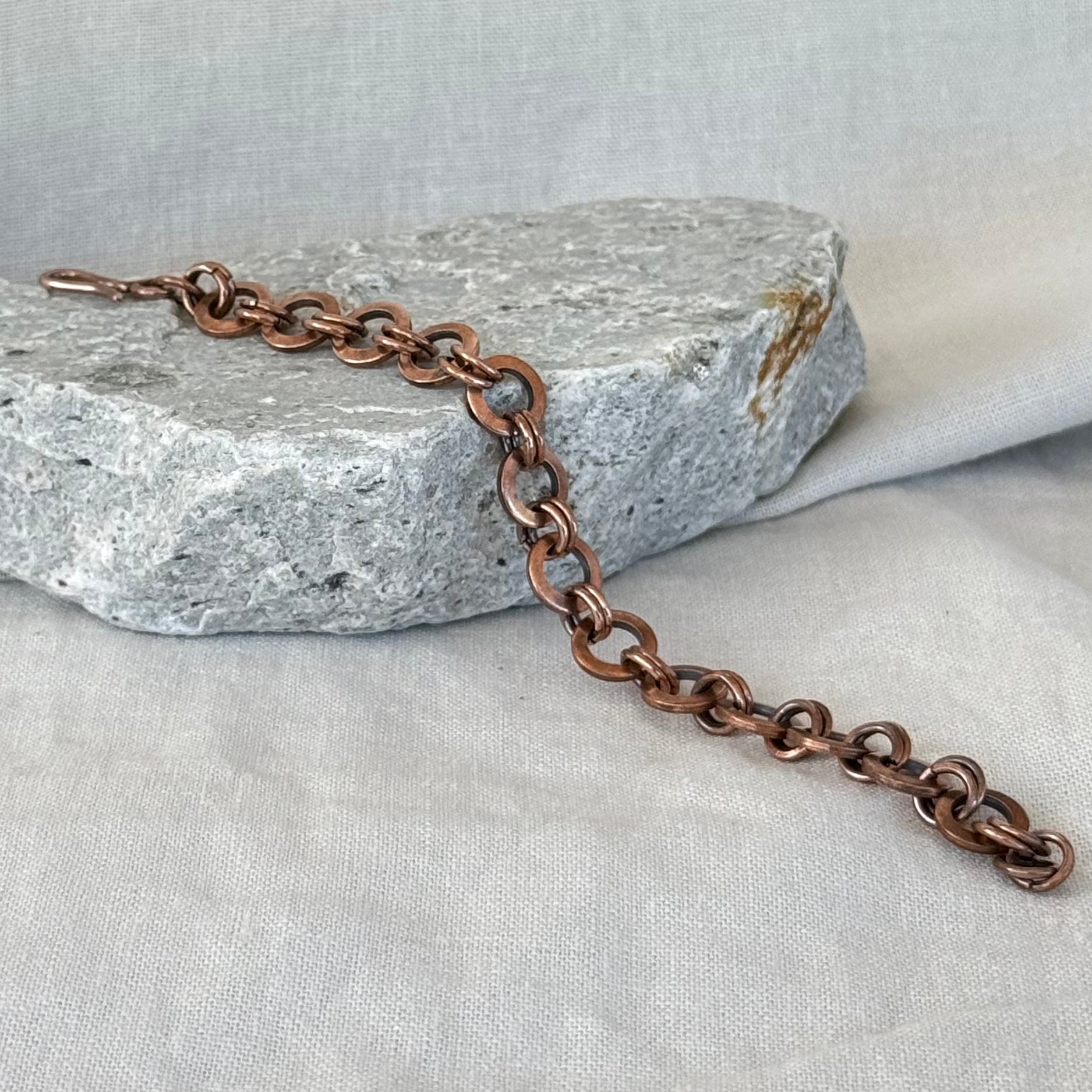 Copper chain bracelet on a textured stone surface