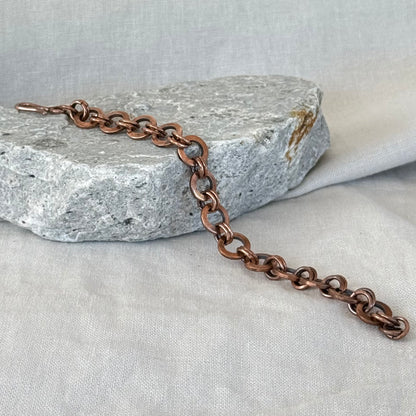 Copper chain bracelet on a textured stone surface