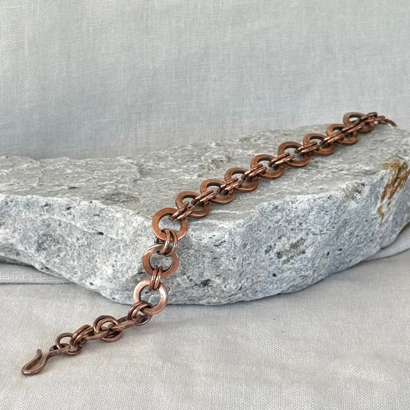 Copper chain bracelet on a stone surface