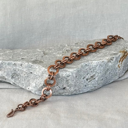 Copper chain bracelet on a stone surface
