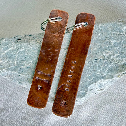 Two copper  keychain against a stone and linen background