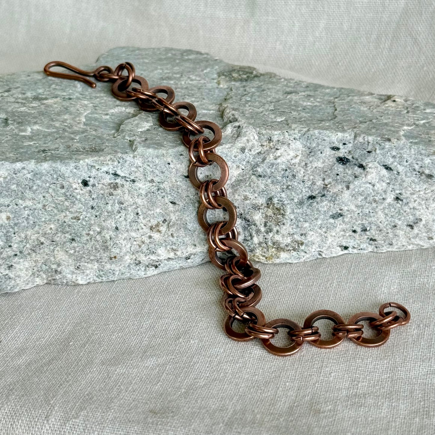 Copper chain bracelet on a textured stone surface
