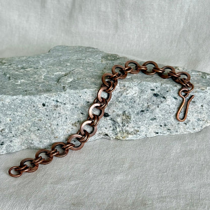 Copper chain bracelet on a textured stone surface