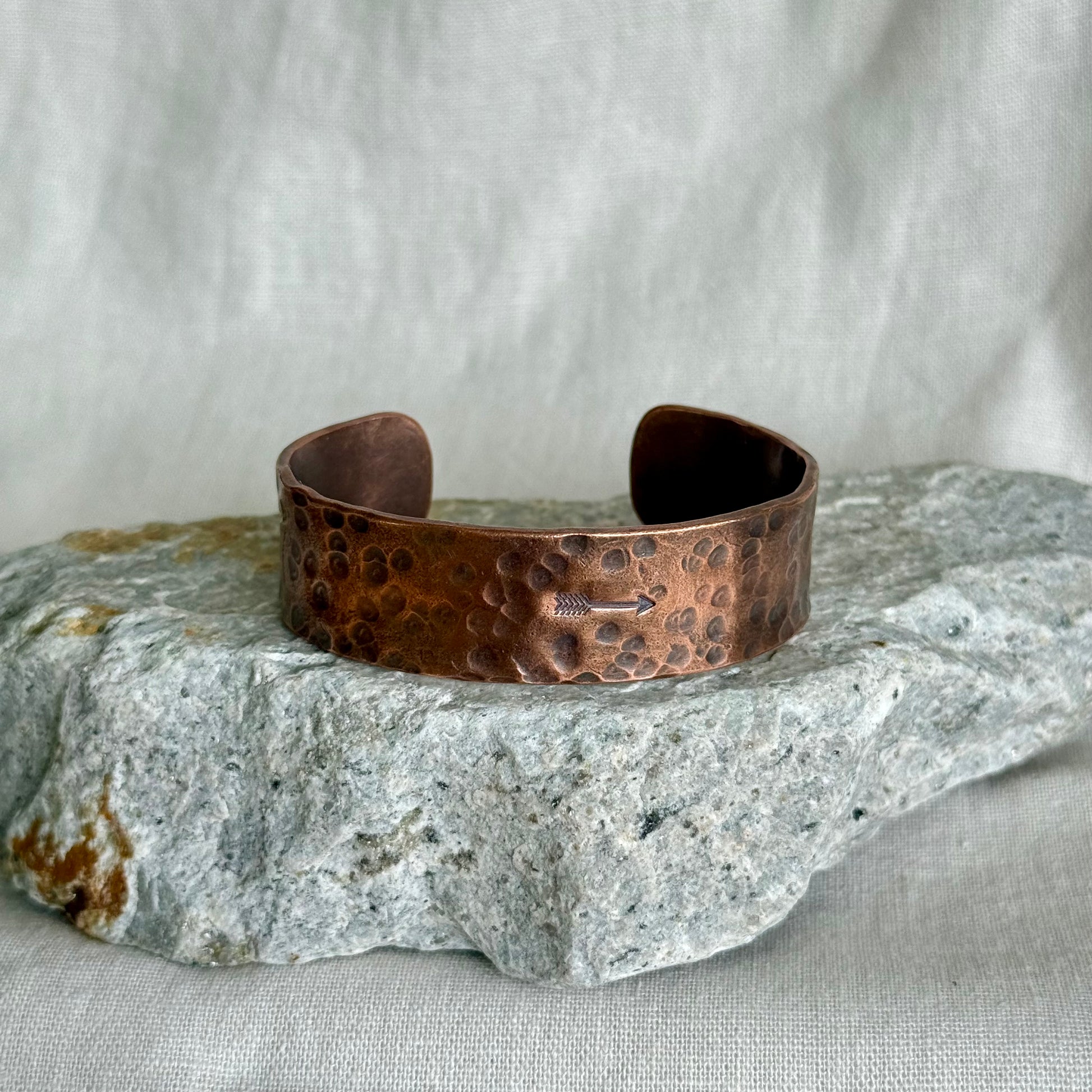 Copper bracelet on a textured stone surface with a neutral background
