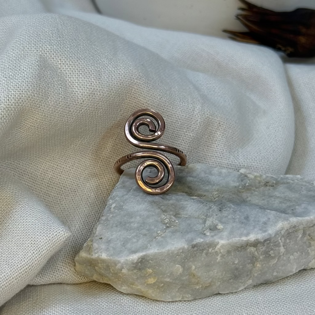 Copper spiral ring on a stone surface with linen background