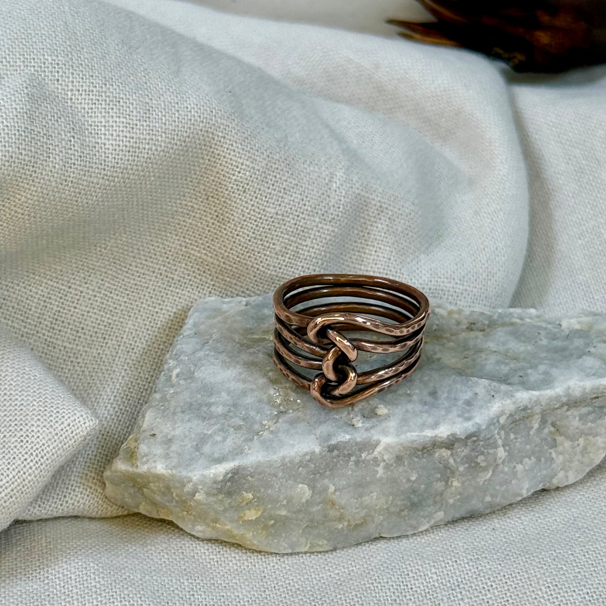 Copper wire ring  on a stone surface with a linen background