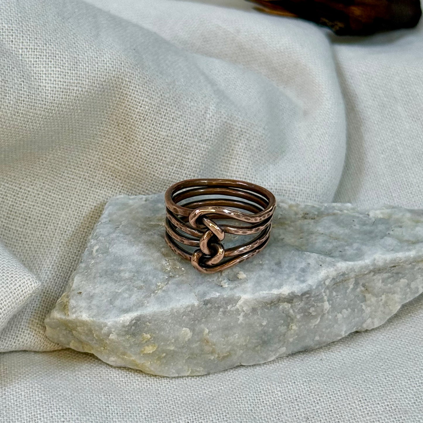 Copper wire ring  on a stone surface with a linen background