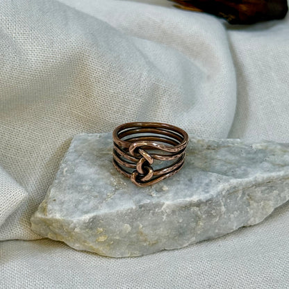 Copper wire ring  on a stone surface with a linen background