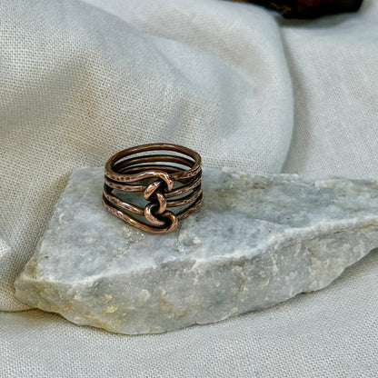 Copper wire ring  on a stone surface with a linen background