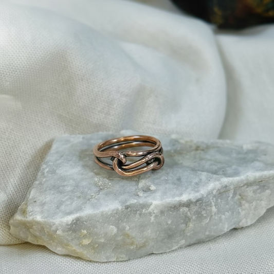Copper wire ring  on a stone surface with a linen background