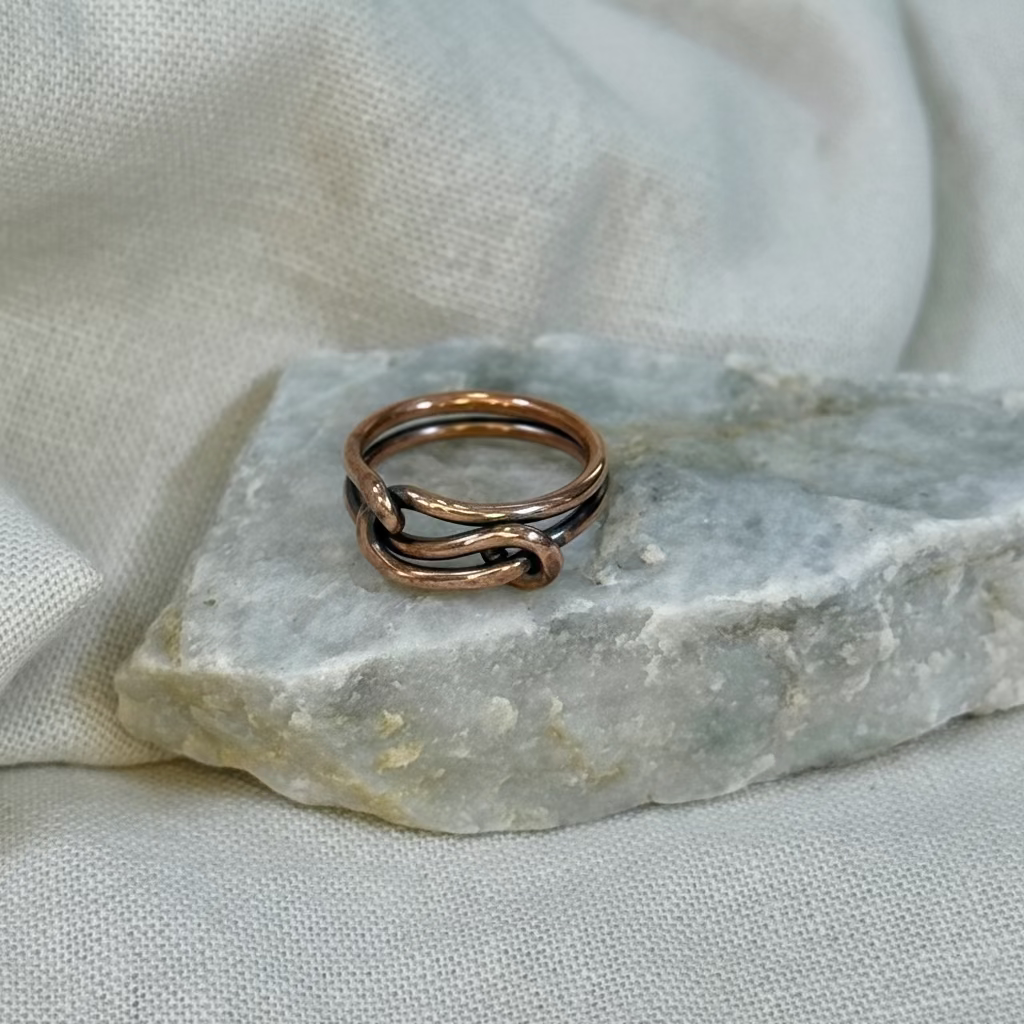 Copper wire ring  on a stone surface with a linen background