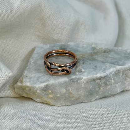 Copper wire ring  on a stone surface with a linen background