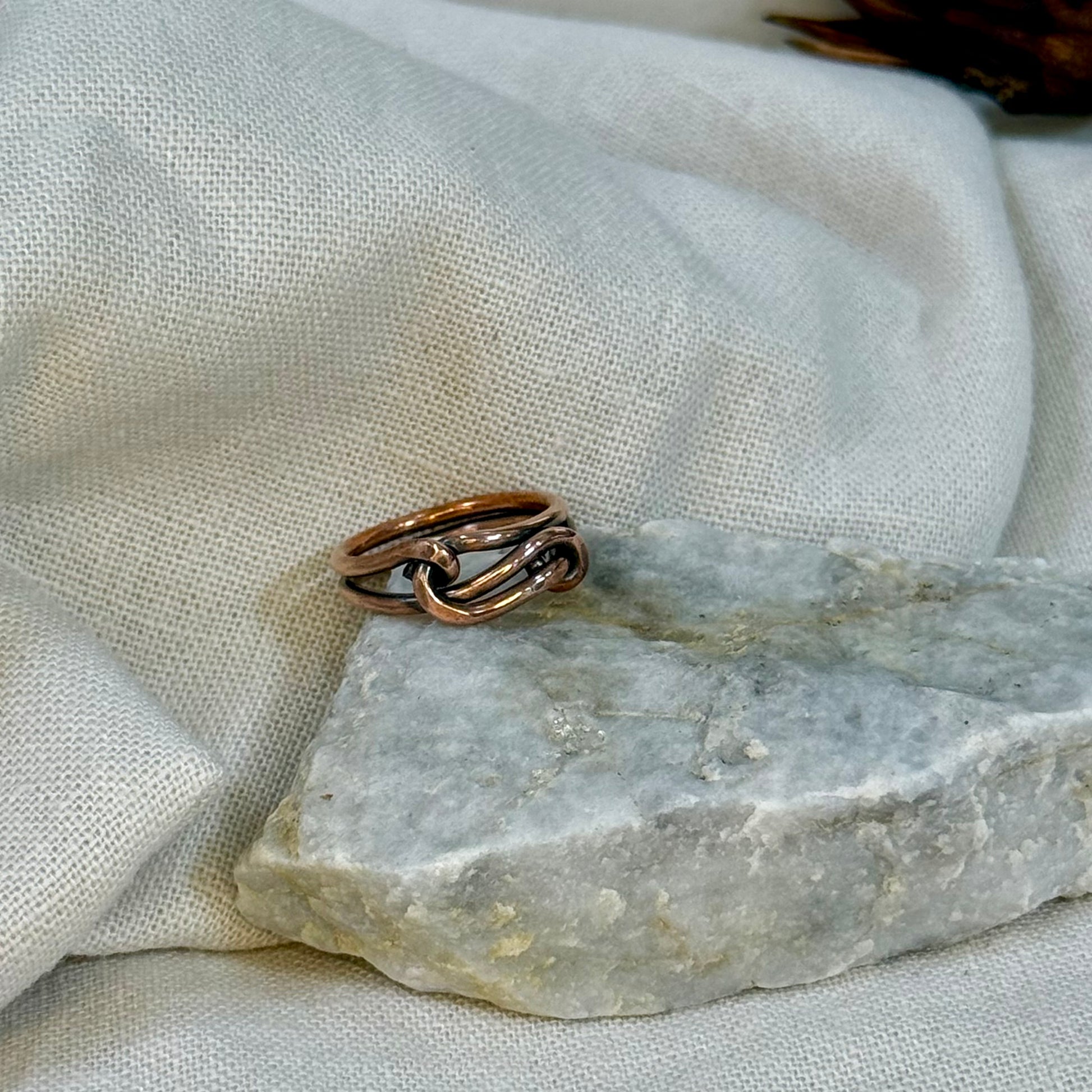 Copper wire ring  on a stone surface with a linen background