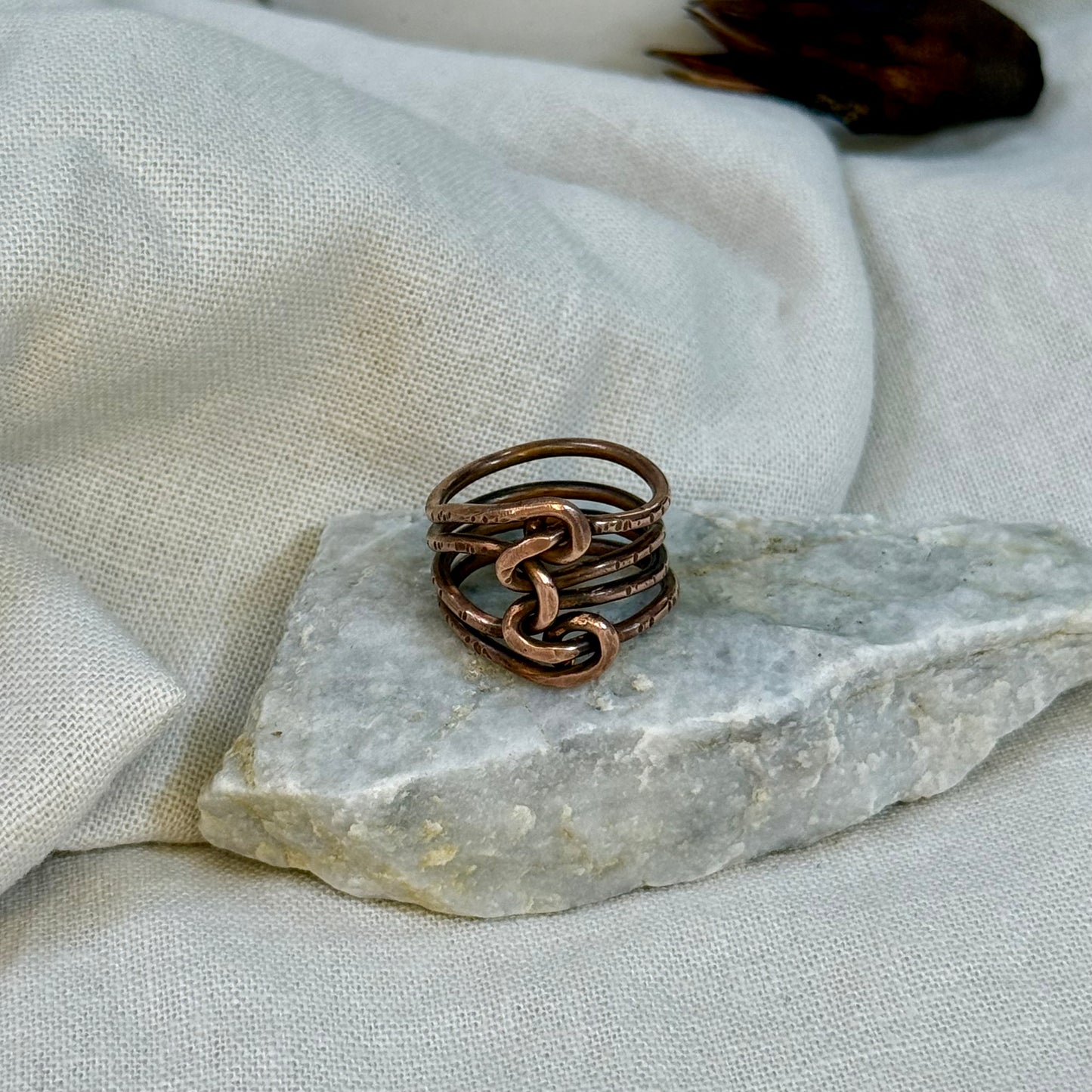 Copper wire ring  on a stone surface with a linen background