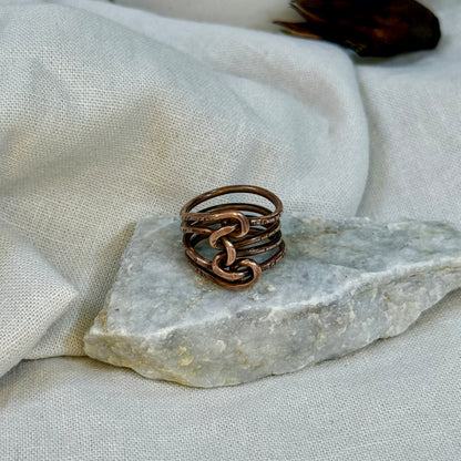 Copper wire ring  on a stone surface with a linen background