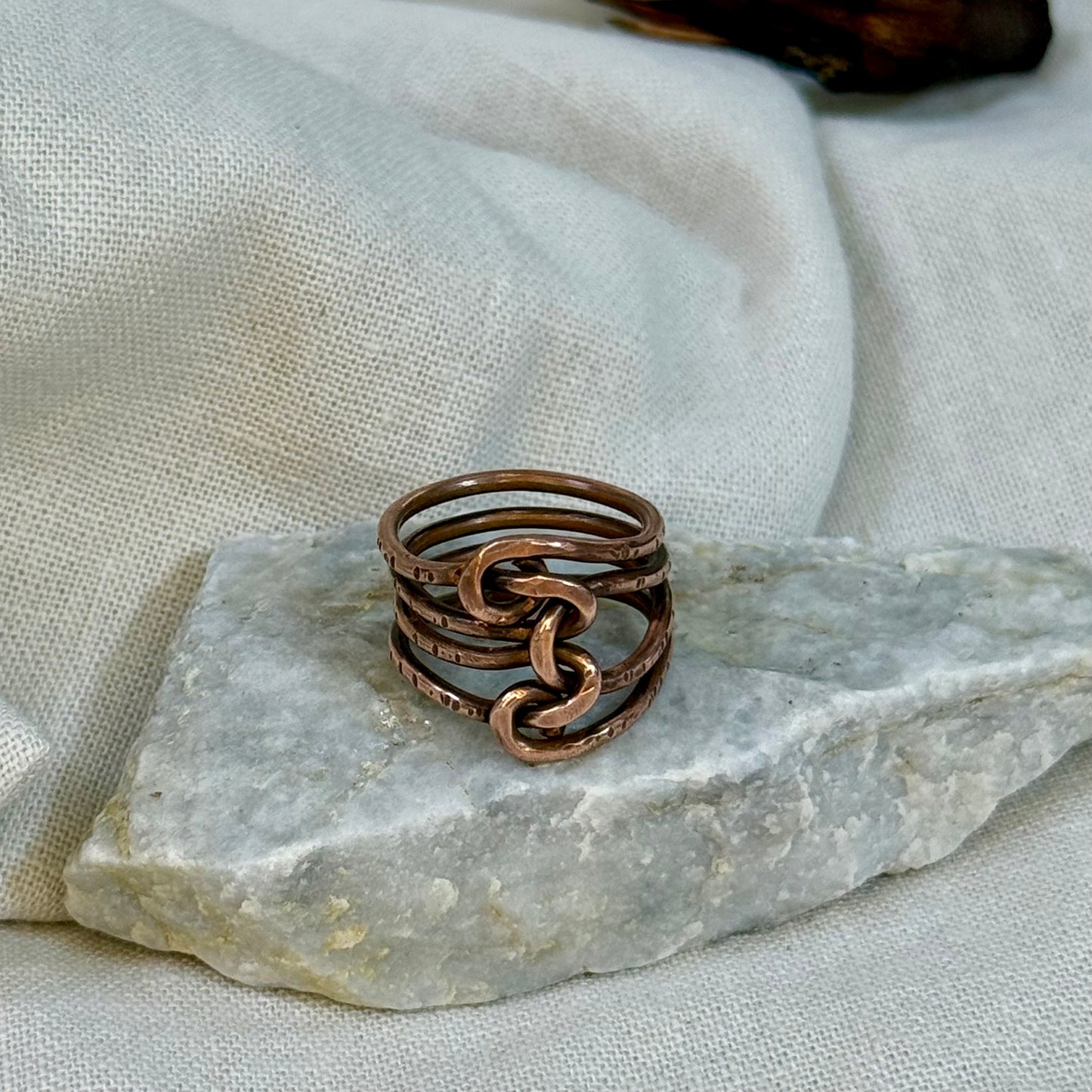 Copper wire ring  on a stone surface with a linen background