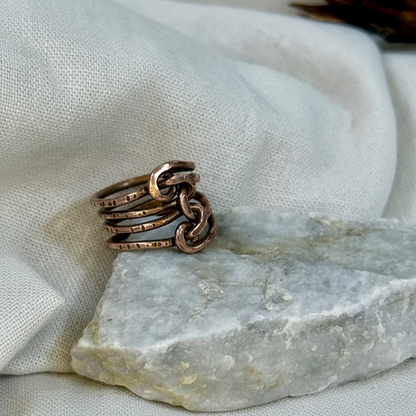 Copper wire ring  on a stone surface with a linen background