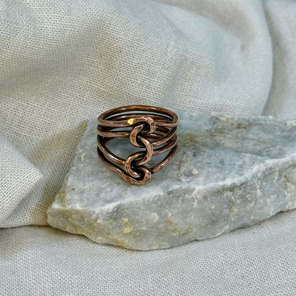 Copper wire ring  on a stone surface with a linen background