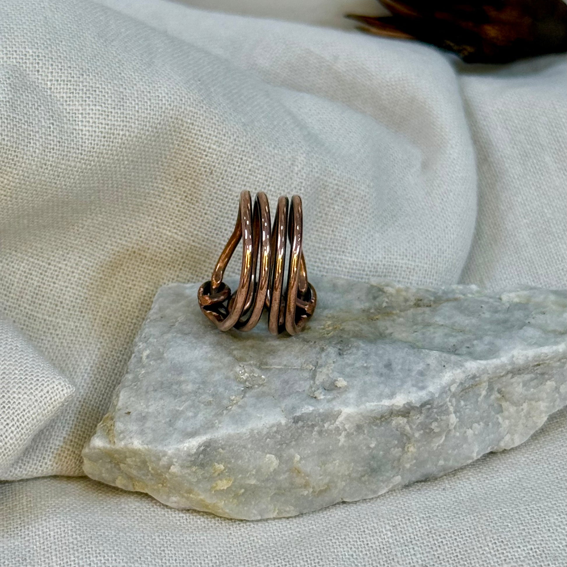 Copper wire ring  on a stone surface with a linen background