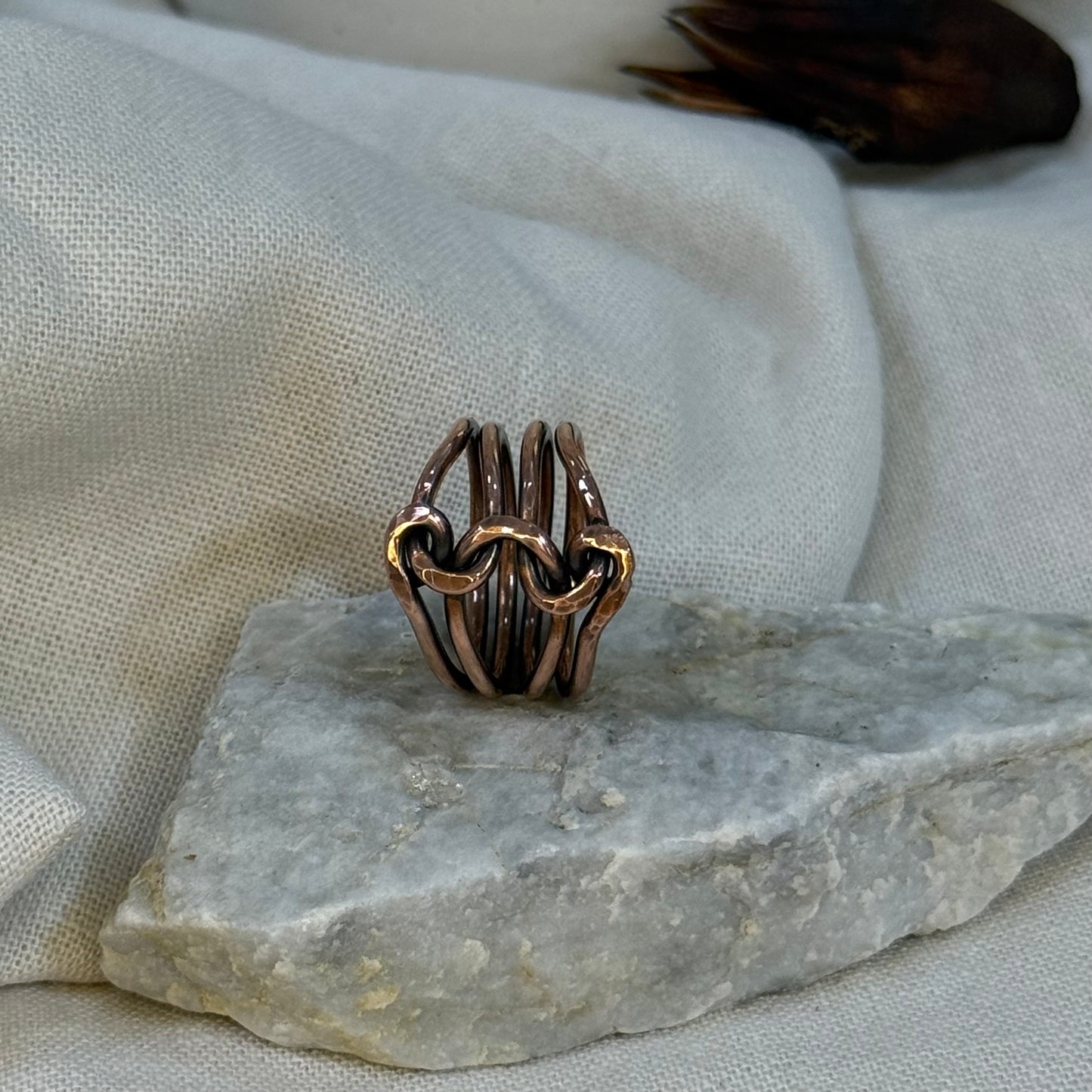 Copper wire ring  on a stone surface with a linen background