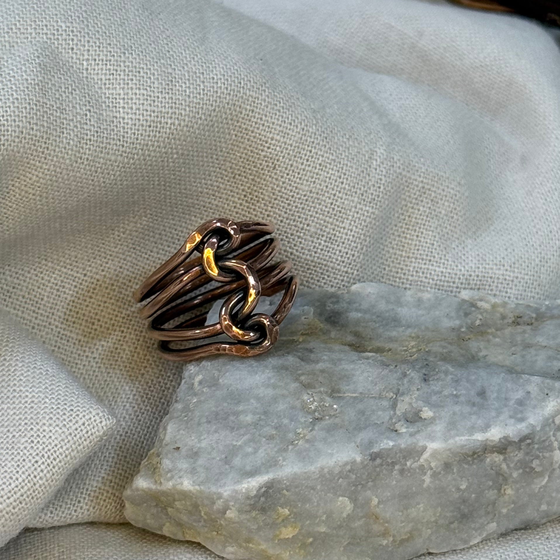 Copper wire ring  on a stone surface with a linen background