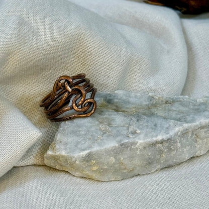 Copper wire ring  on a stone surface with a linen background