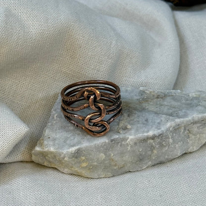 Copper wire ring  on a stone surface with a linen background