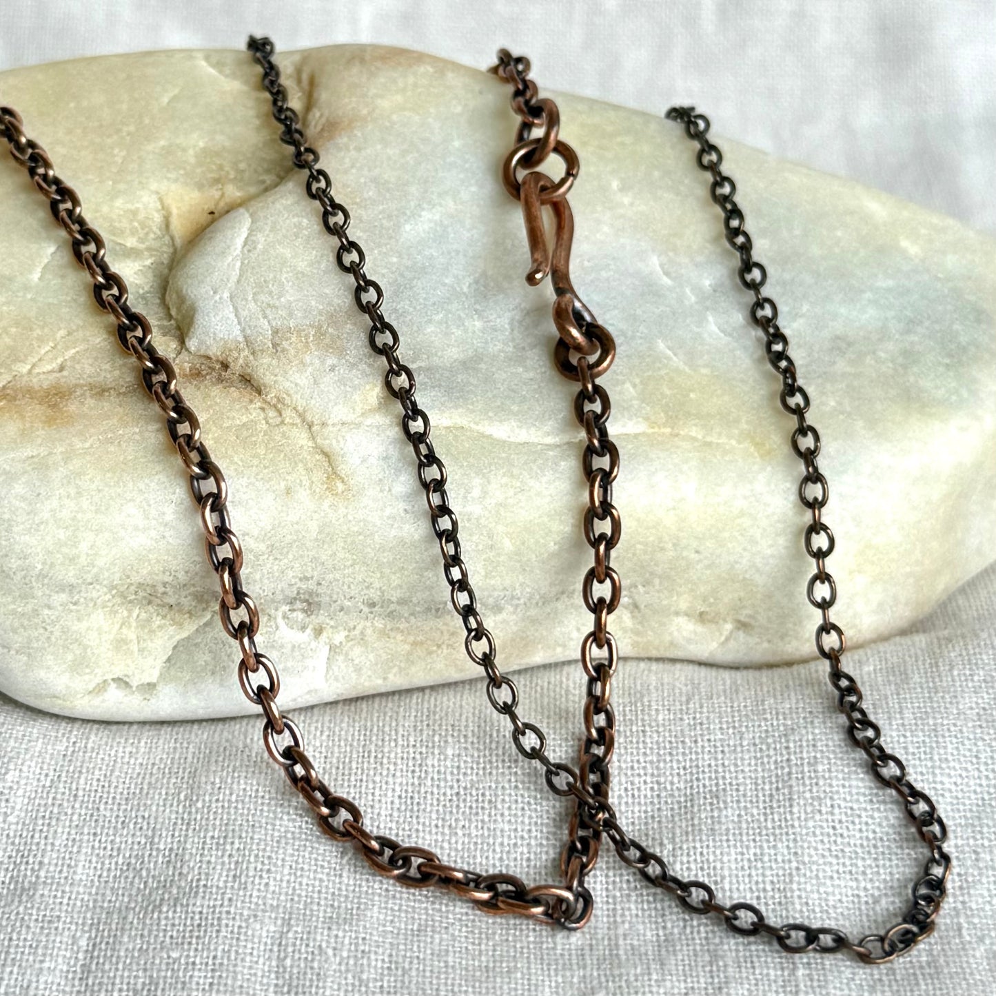 Copper chain necklace on a stone surface