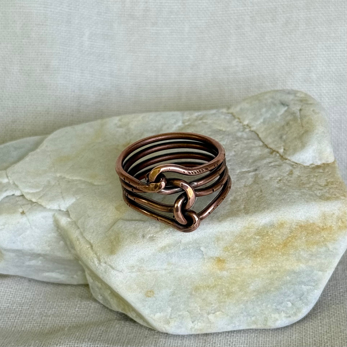Copper ring on a piece of stone with a neutral background