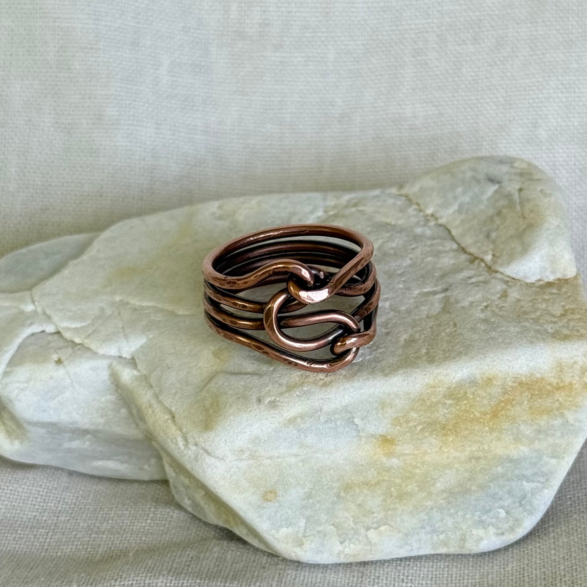 Copper ring on a piece of stone with a neutral background