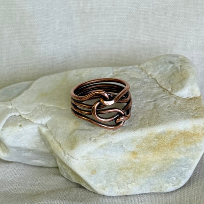 Copper ring on a piece of stone with a neutral background